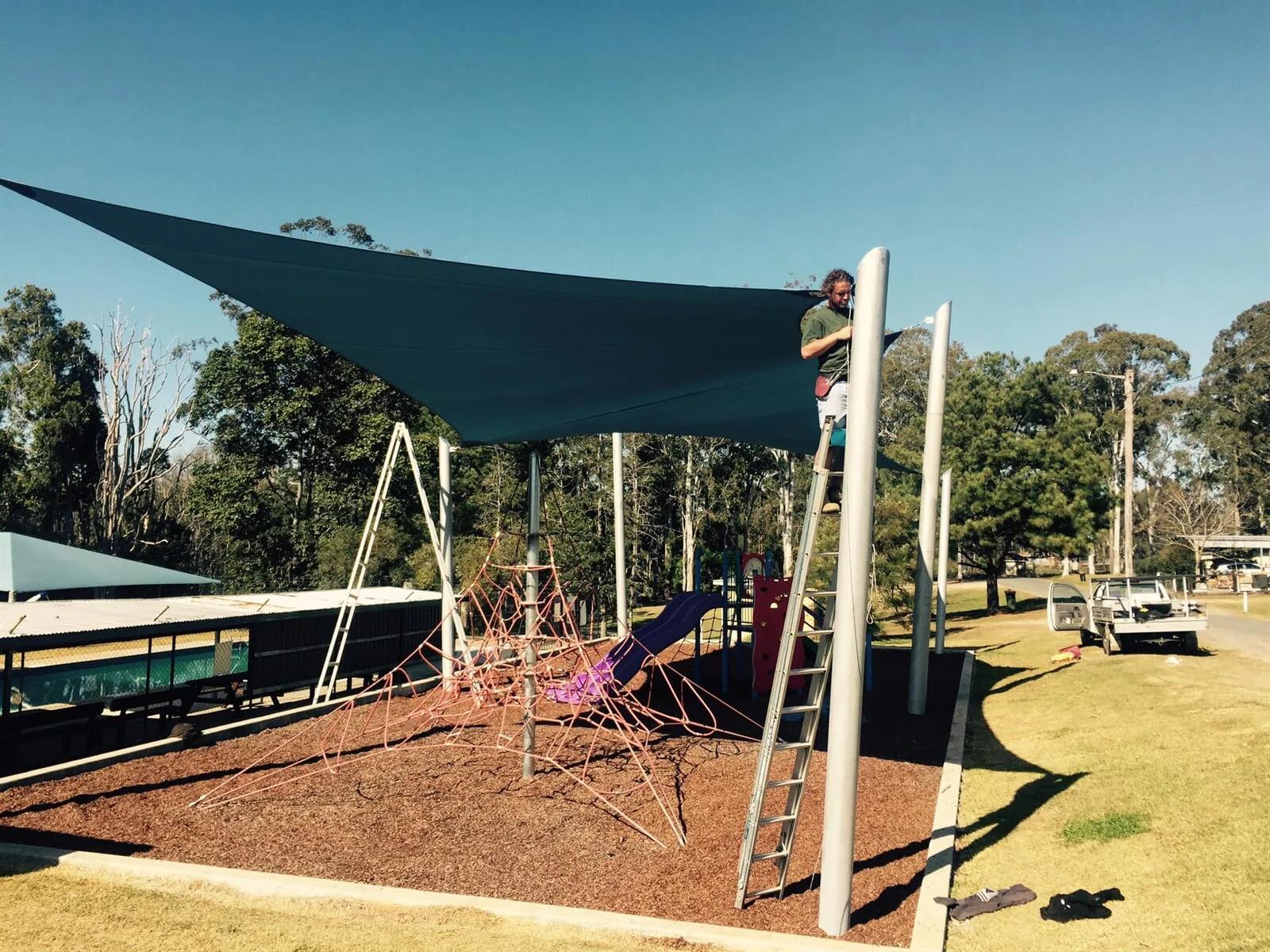 Blue cantilever outdoor umbrella shading a poolside lounge area